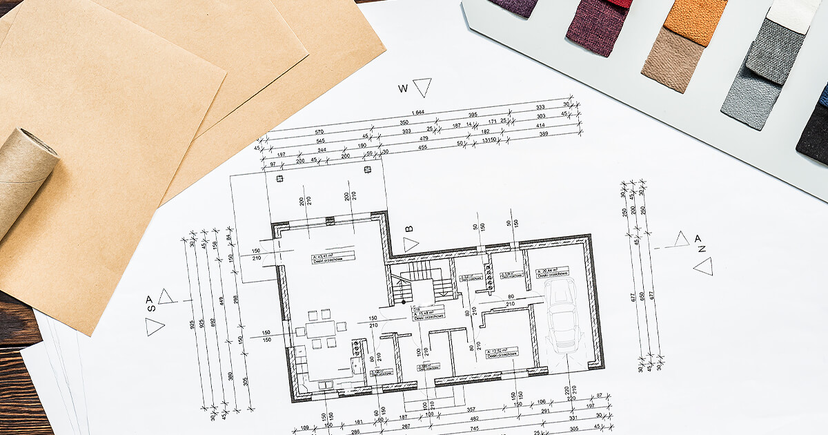 View of house plans on paper with material swatches to the side planning for house build costs
