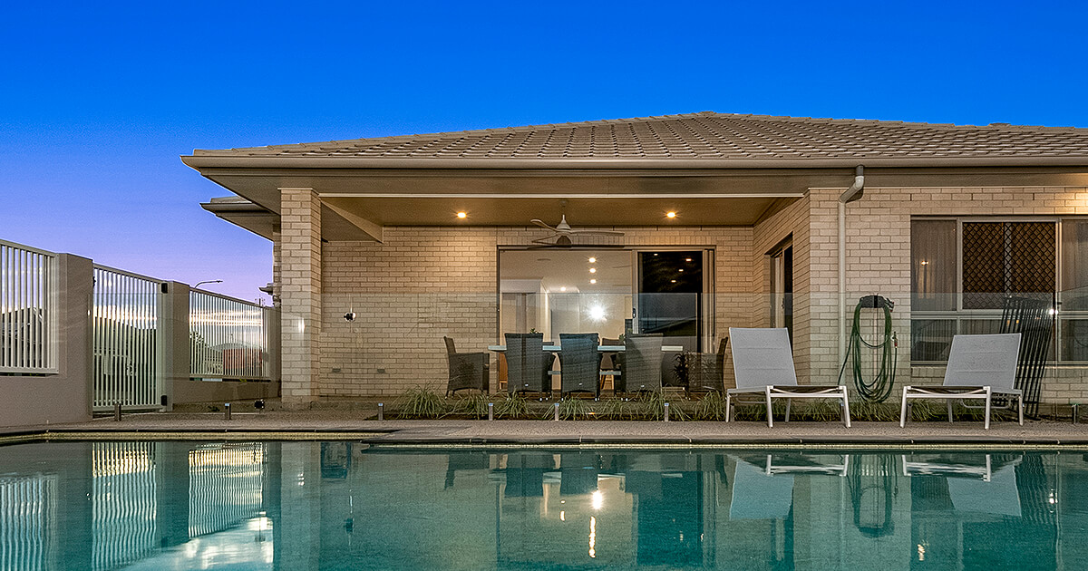 A large entertainment area reflected in pool in the foreground