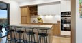 Modern white and timber kitchen with centre island and stools