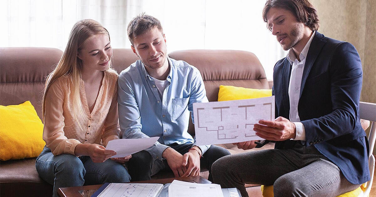 Building showing young couple plans of their new home before building