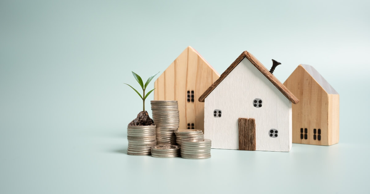 House with coins and a plant growing