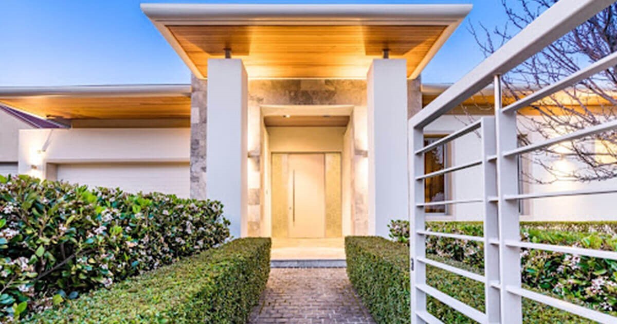 White home exterior with lighting and gate
