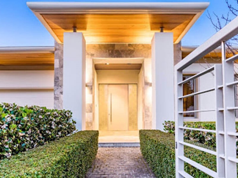 White home exterior with lighting and gate