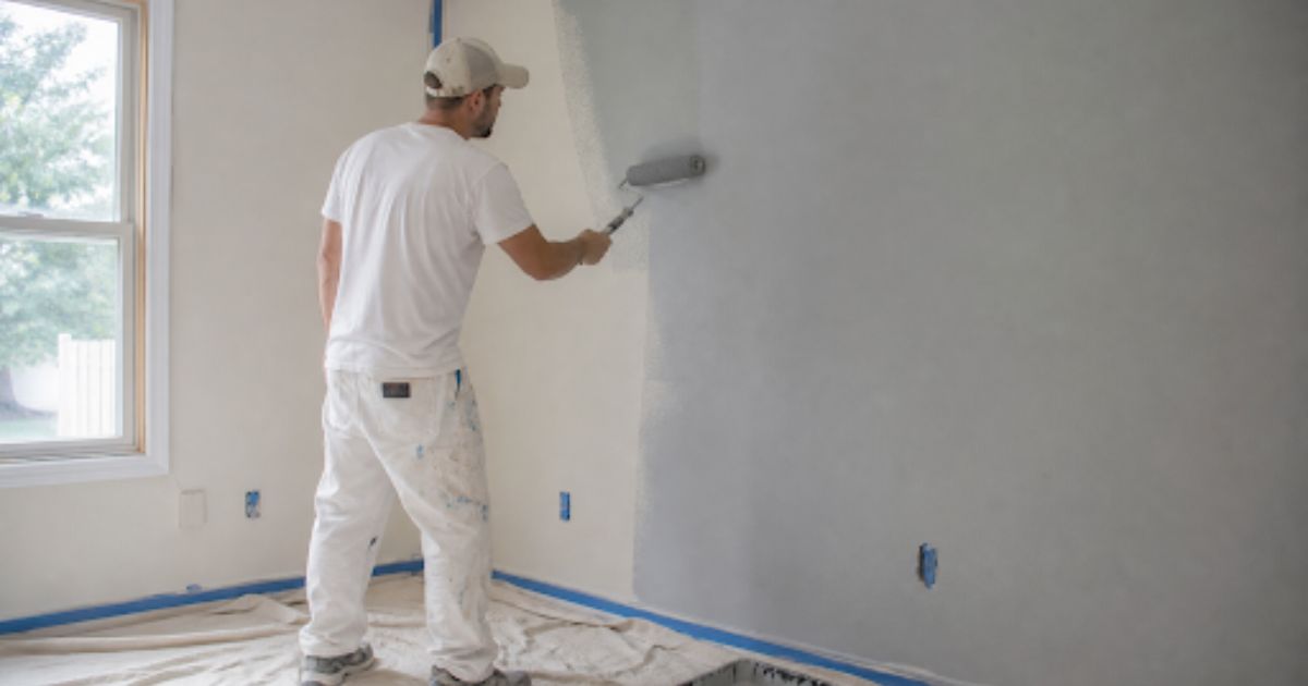 Man painting interior of house